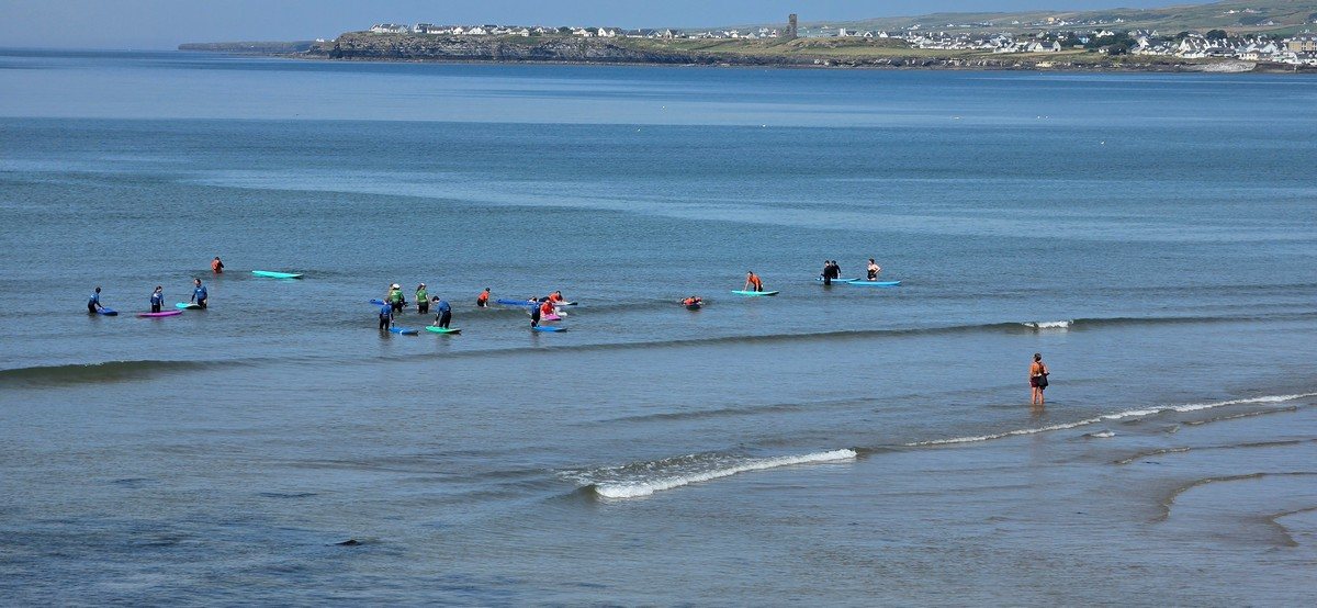 a few beginners catching the ripples on the main beach